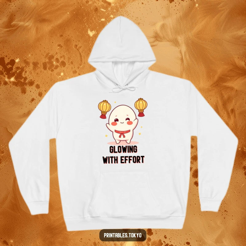 Funny hoodie showing a cheerful mochi character with rosy cheeks, attempting to juggle bright lanterns, offering warmth and playful humor.